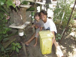 Paulo e seu filho Isaac entre as colmeias: falta de ferrões facilita manejo. Foto: Fábio Barcelos